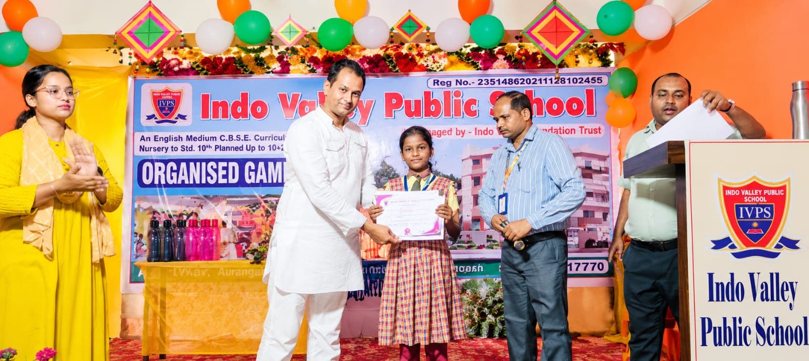 A student receiving a prize certificate on stage