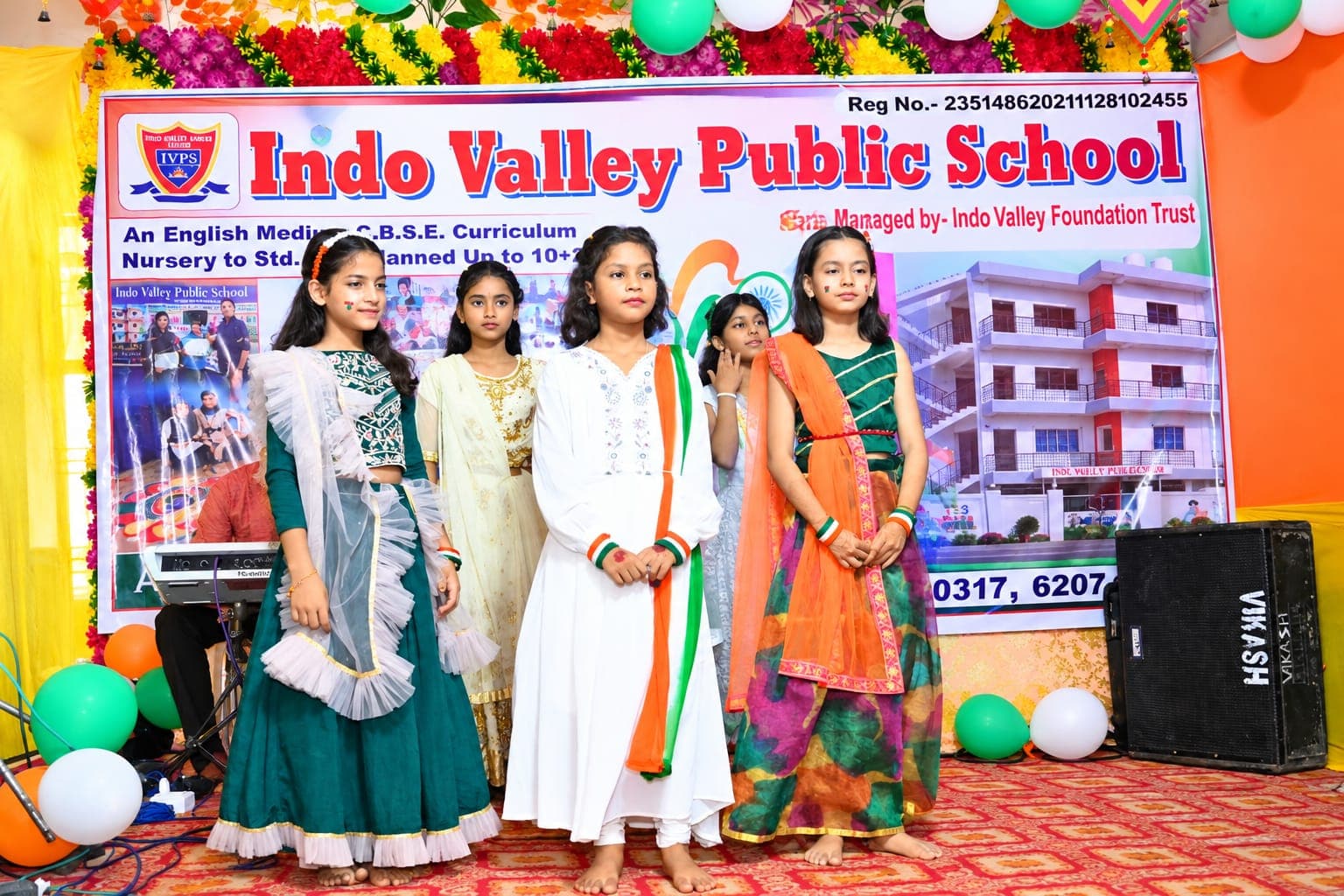 A group of students in tricolour outfits on stage for Independence Day