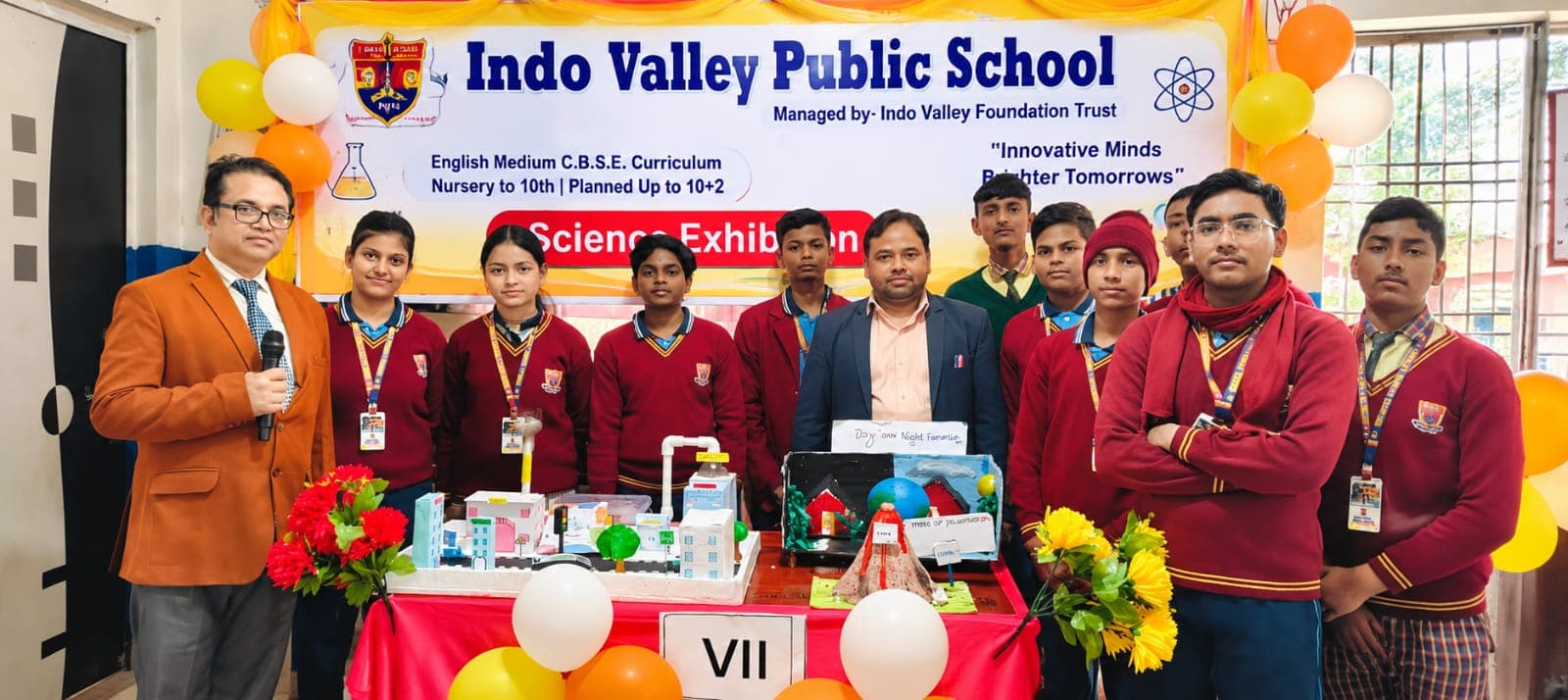 Students presenting science exhibition models with their teachers